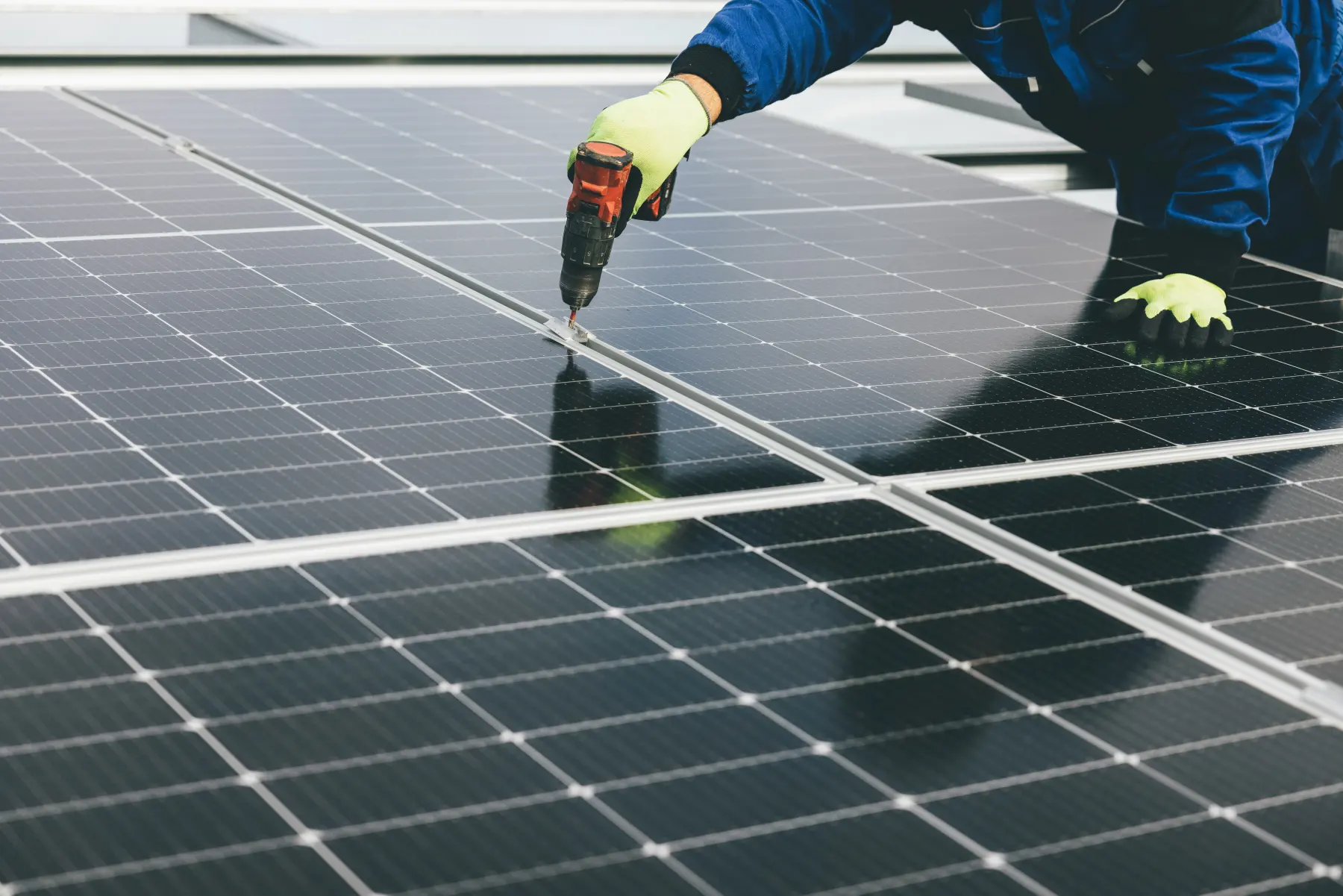 Técnico atornillando un módulo fotovoltaico durante una instalación
