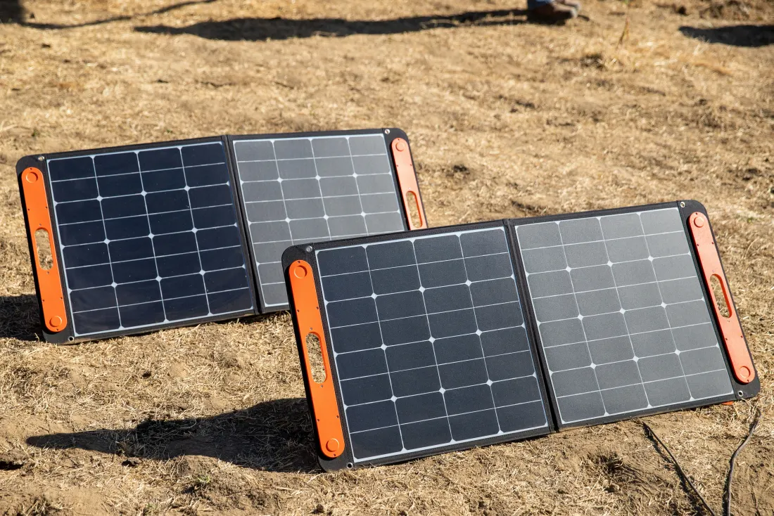 Paneles solares plegables desplegados en exterior sobre terreno seco